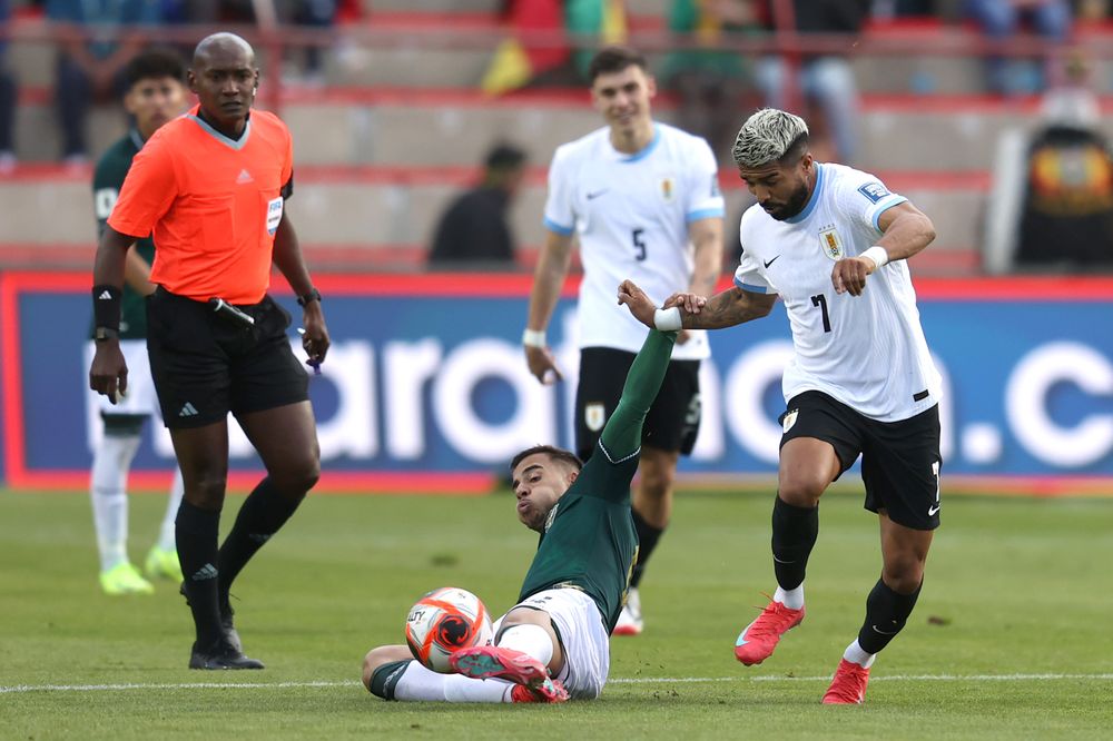 Robson Matheus de Bolivia disputa un balón con Rodrigo Aguirre de Uruguay por Eliminatorias