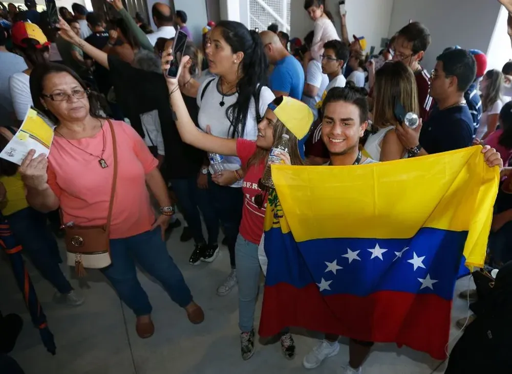 Venezuelan citizens line up to vote in a non-binding referendum against the Venezuelan governements plans to re-write their constitution to stay in power in Miami, Florida, on July 16, 2017.    In Miami, Madrid and elsewhere Venezuelans living abroad enthusiastically cast ballots in a vote organized by the opposition that sought to undermine unpopular President Nicolas Maduro. / AFP / RHONA WISE