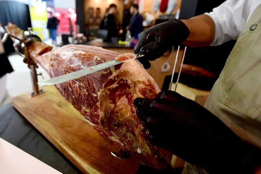 Una persona corta jamón serrano. EFE  