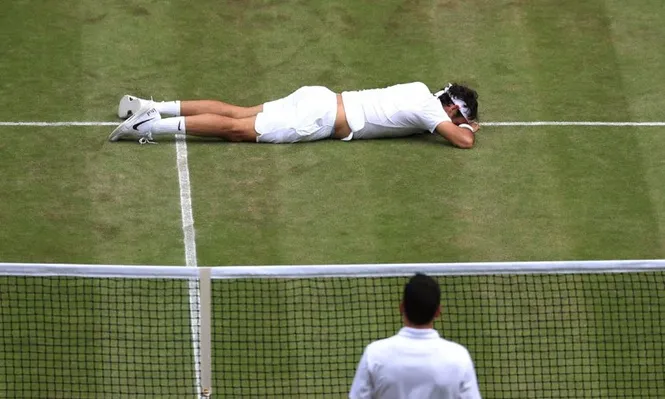 Federer en el piso tras su resbalón; puede estar lesionado