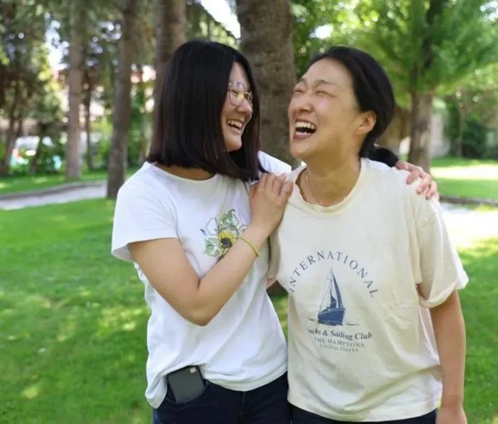 Hai, la joven nacida en Seúl, junto a su madre tras obtener la mejor calificación.
