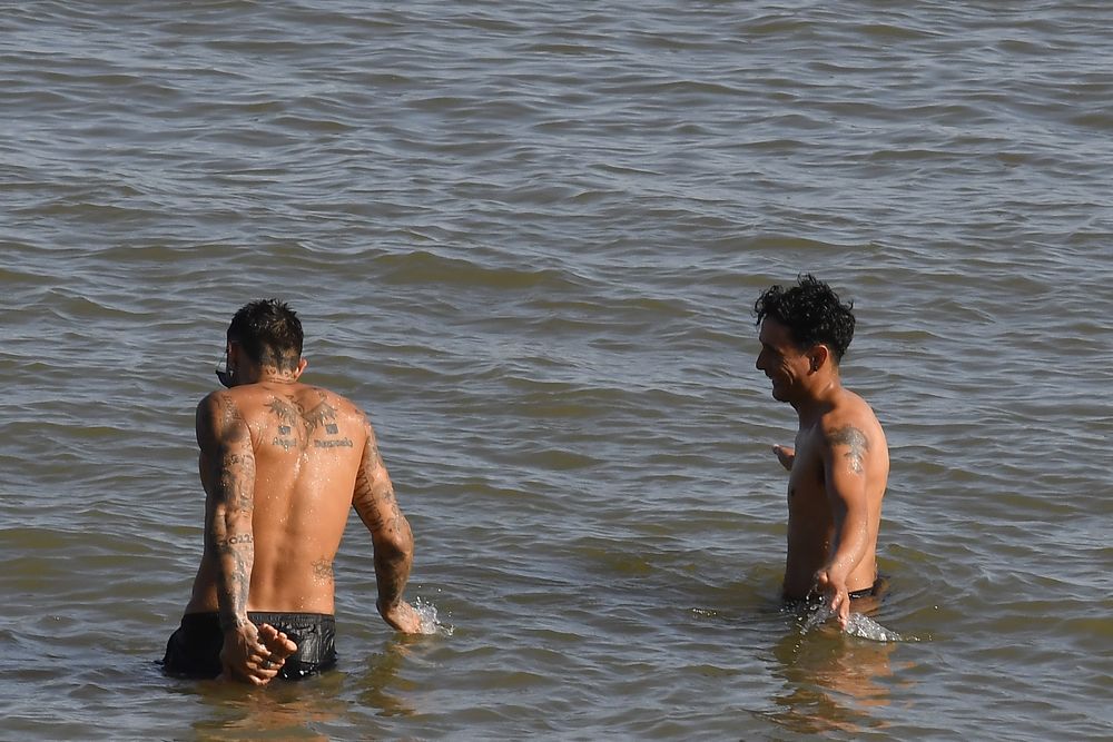 Personas bañándose en una playa