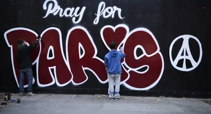 Dos hombres pintan un mural en París tras el ataque terrorista