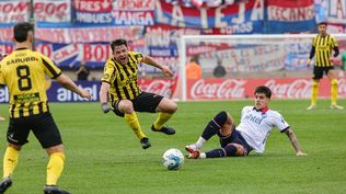 Lucas Hernández de Peñarol recibe una fuerte falta de Alexis Castro de Nacional en la final del Torneo Intermedio