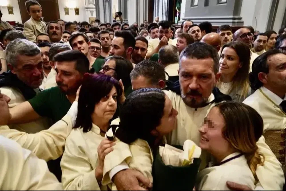 Antonio Banderas consuela a sus compañeras de procesión en Málaga.