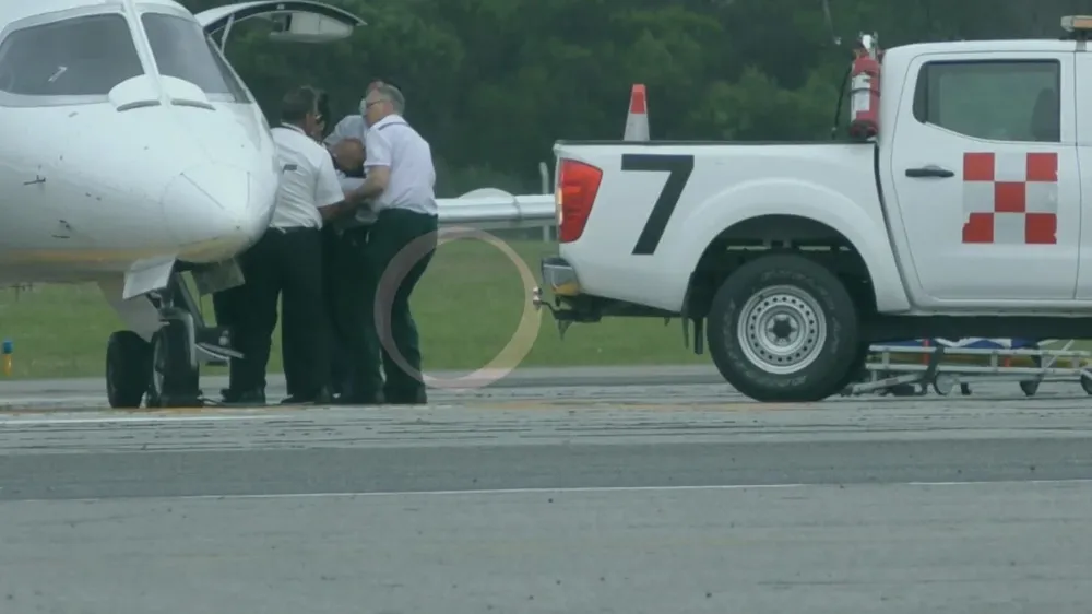 Ezequiel Lavezzi en camilla, siendo subido al avión
