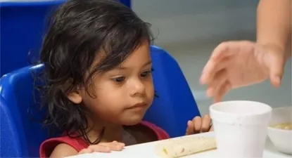 Una niña mira un vaso de sopa en un centro de detención de inmigrantes en la ciudad fronteriza de McAllen, en Texas.
