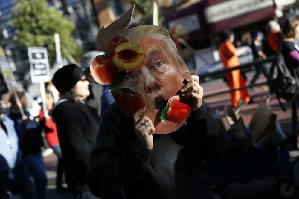 Un protestante muestra una fotografía de Donald Trump