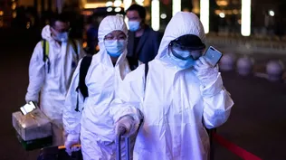 Los pasajeros usan traje anticovid cuando llegan a la estación de tren de Wuhan Wuchang en Wuhan, en abril de 2020