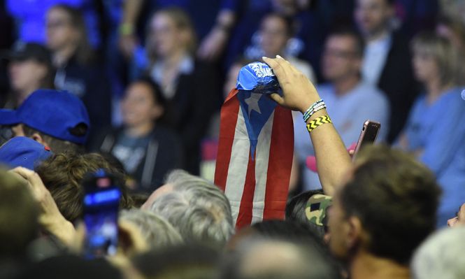 Un asistente flamea la bandera de Puerto Rico durante un acto demócrata en Filadelfia