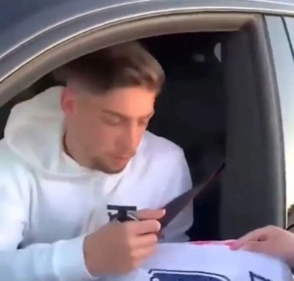 Federico Valverde le firma su camiseta de Real Madrid a una hincha de Peñarol que le mostró la camiseta aurinegra en Madrid