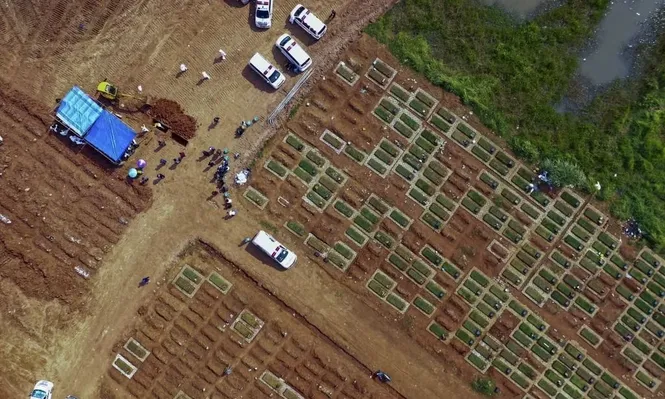 Operarios quemando los cuerpos de las víctimas de coronavirus en Indonesia