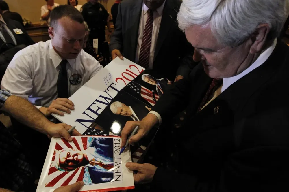 El candidato presidencial republicano Newt Gingrich firmando autógrafos