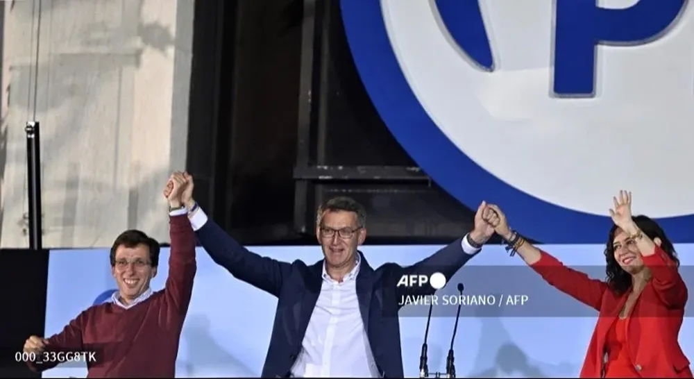 Núñez Feijóo, Díaz ayuso y Martínez Almeida celebran en el balcón de la sede de Génova.