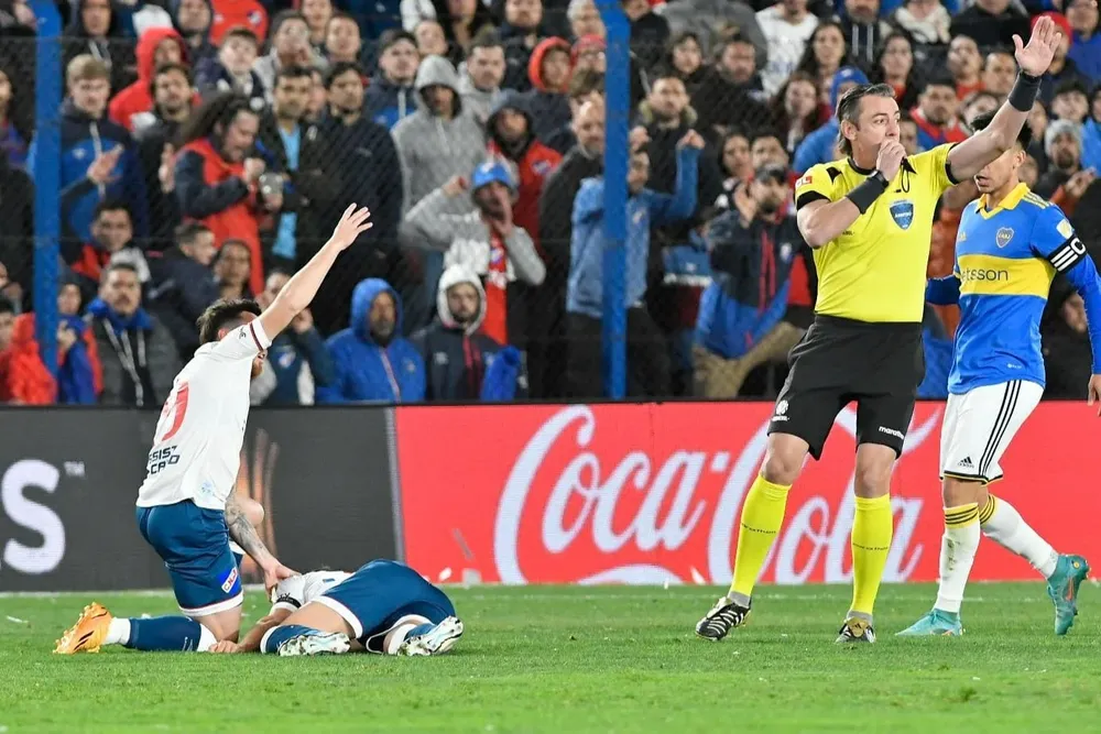 Alfonso Trezza y el árbitro Raphael Claus, piden que entre el médico de Nacional para atender a Diego Rodríguez, desmayado en la cancha ante Boca