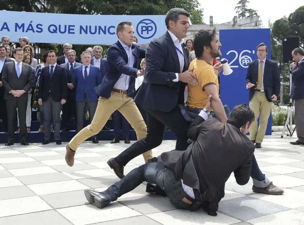 Seguridad retiene a un hombre protestando frente al Primer Ministro en España.