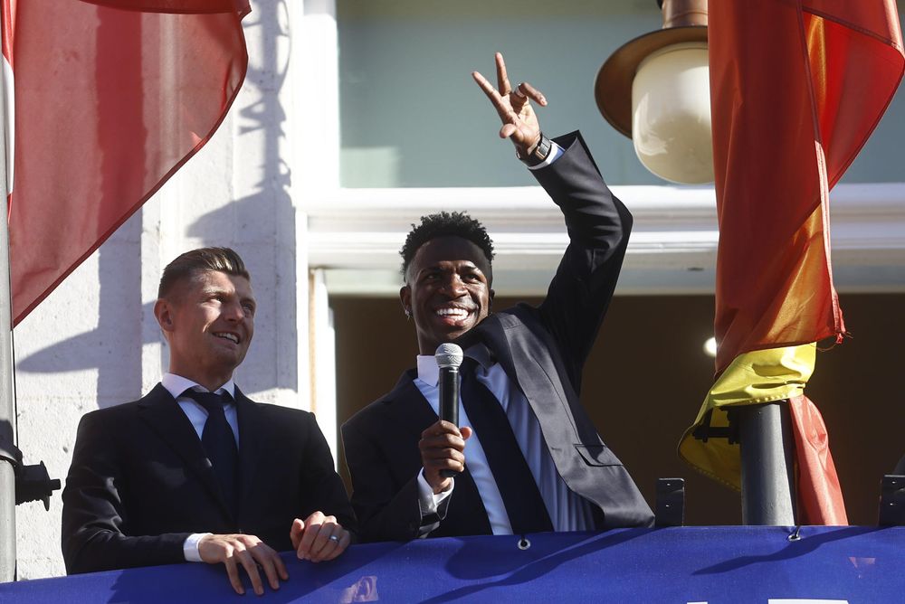 Los jugadores Vinicius jr. y Toni Kroos saludan a los aficionados desde del balcón de la Real Casa de Correos, sede de la Comunidad de Madrid