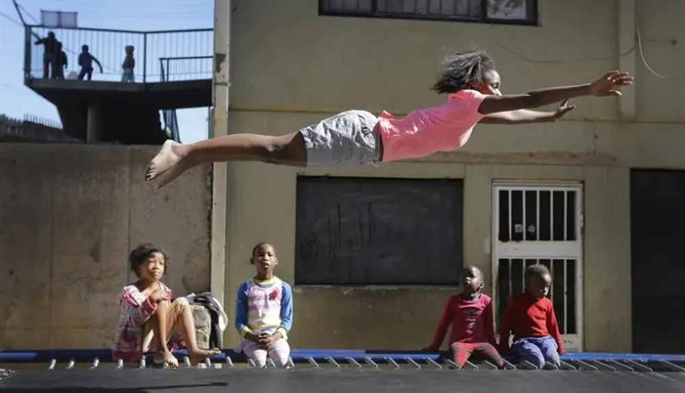 Sudáfrica. Una niña realiza acrobacias en una cama elástica, en Johannesburgo