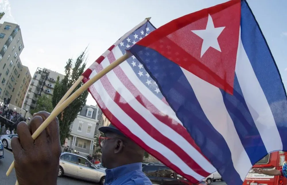 Un hombre ondea las banderas de Estados Unidos y Cuba (archivo)