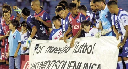Los jugadores de Juventud y Nacional salieron con una pancarta en pos de la unión de los futbolistas