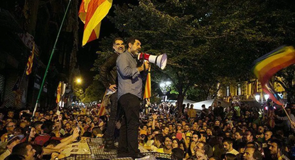 Los independentistas Sánchez y Cuixart, encima de un coche de la Guardia Civil durante los incidentes del 20 de septiembre de 2017.
