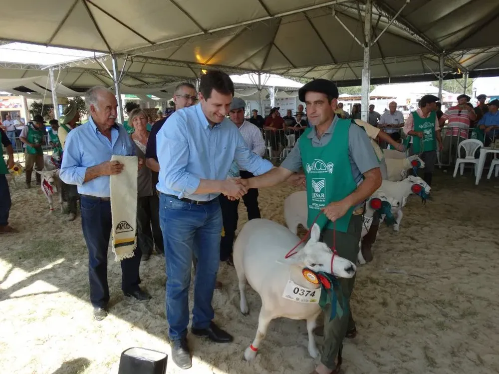 Ernani Polo, secretario estadual de Agricultura, saluda al cabañero de la Gran Campeona Texel.