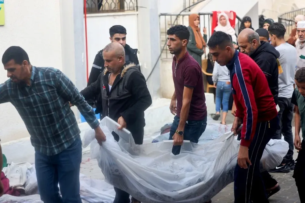 Palestinos llevan el cadáver de un ciudadano de Gaza. El ministerio de Sanidad de Hamás afirma que en los últimos bombardeos murieron más de 700 personas.