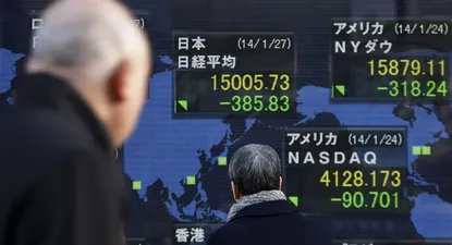 Japón- Peatones se detienen ante una pantalla electrónica con los resultados de la Bolsa de Tokio