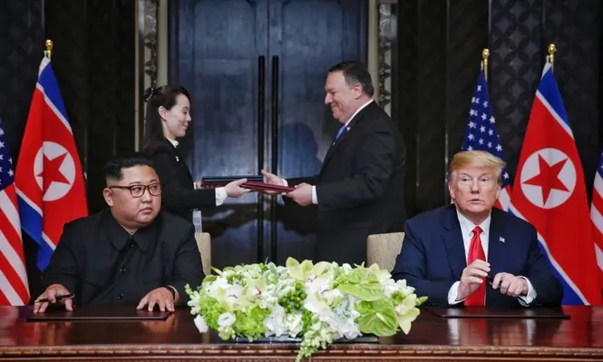 This handout photo taken on June 12, 2018 and released by The Straits Times shows US President Donald Trump (R) and North Koreas leader Kim Jong Un (L) looking on as documents are exchanged between US Secretary of State Mike Pompeo (2nd R) and the North Korean leaders sister Kim Yo Jong (2nd L) at a signing ceremony during their historic US-North Korea summit, at the Capella Hotel on Sentosa island in Singapore. Donald Trump and Kim Jong Un became on June 12 the first sitting US and North Korean leaders to meet, shake hands and negotiate to end a decades-old nuclear stand-off.Kevin LIM / THE STRAITS TIMES / AFP