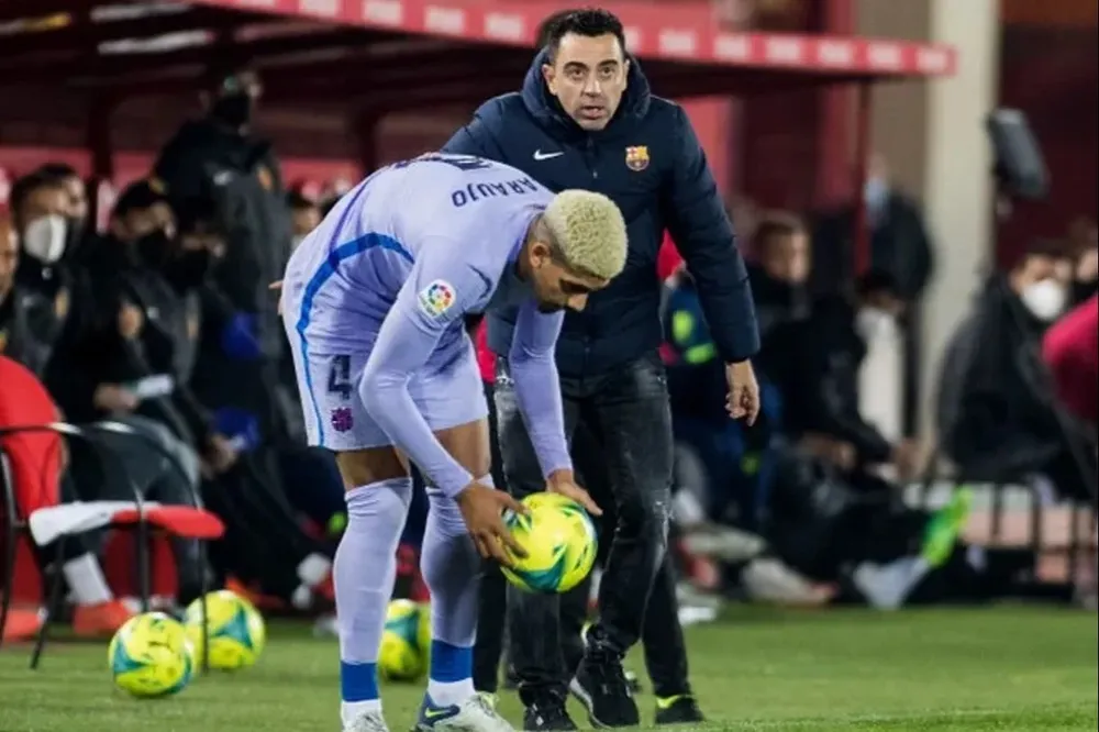 Xavi dirigiendo a Ronald Araujo en un partido de Barcelona