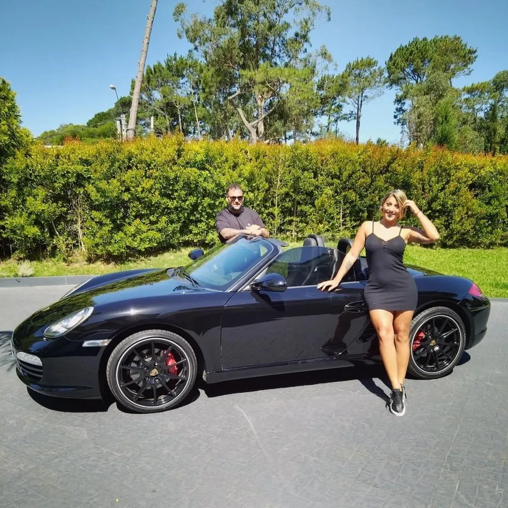 Romina Camejo posa junto a Gonzalo Aguiar frente a un Porsche negro