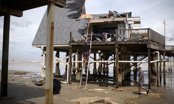 Mike Isbell (centro) sube una escalera para observar los restos de su casa que fue destruida en Surfside Beach, Texas, el 8 de julio de 2024, después de que el huracán Beryl tocara tierra.