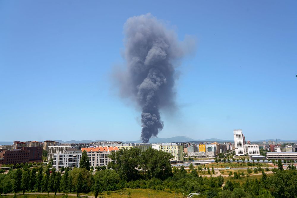 Una densa columna de humo se desprende de la fábrica incendiada.