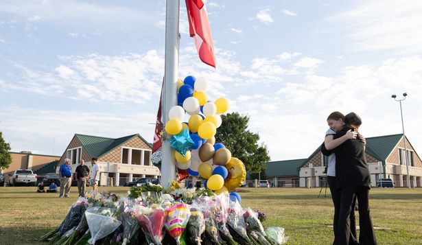 Dos alumnos se abrazan frente al memorial por las víctimas del tiroteo en la escuela de Georgia