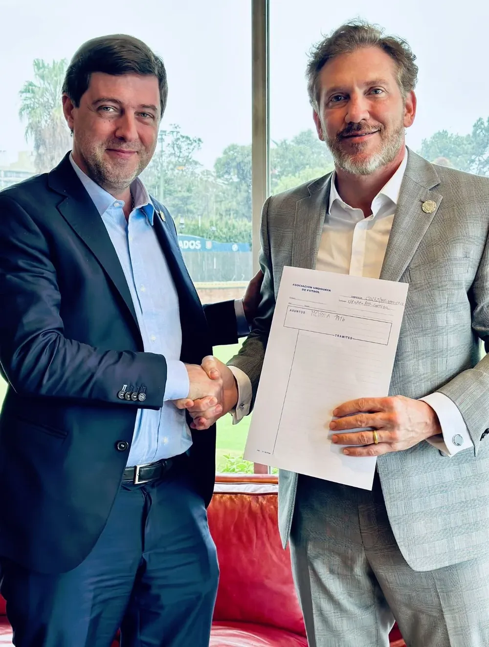 Ignacio Alonso, presidente de la AUF, y Alejandro Domínguez, titular de Conmebol, con la primera memoria de la historia de la Conmebol que encontraron los funcionarios de la AUF
