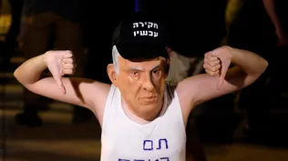 Manifestante israelí con una máscara de Netanyahu y una frase que dice en hebreo el juego se ha terminado
