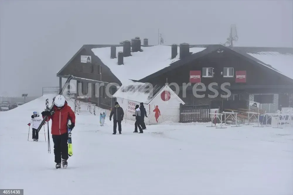 Varias personas caminan por la nieve en el día que comienza la temporada de esquí, en la estación de Candanchú, en Huesca, Aragón (