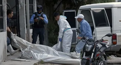 Personal forense retira cuerpos de víctimas de la masacre en Honduras