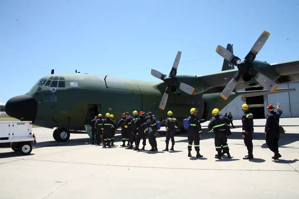 Bomberos uruguayos abordan el Hércules en la base de la Fuerza Aérea.