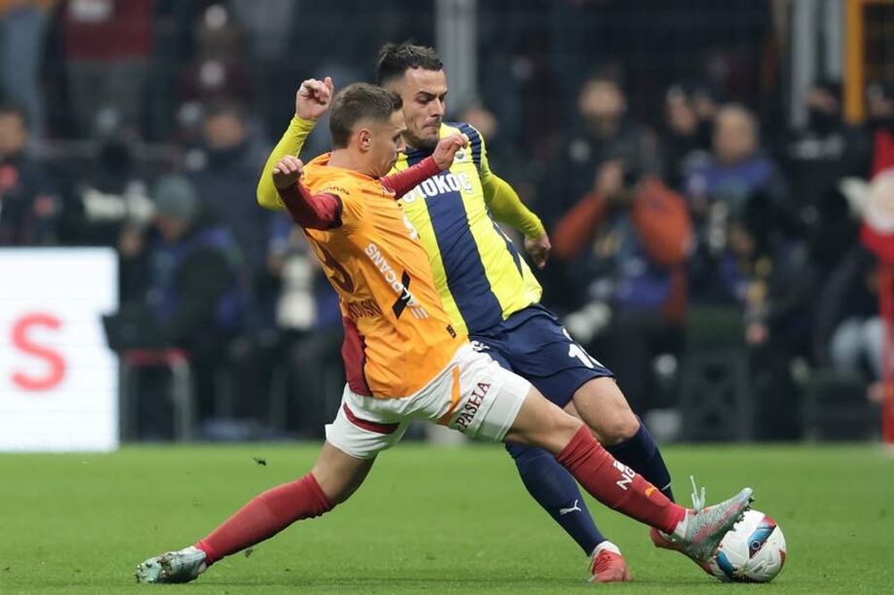 Adam Frankowski (izq.) del Galatasaray en acción contra Filip Kostic (der.) del Fenerbahçe durante el derbi de la Superliga turca entre el Galatasaray y el Fenerbahçe en Estambul, Turquía, el 24 de febrero de 2025. (EFE)