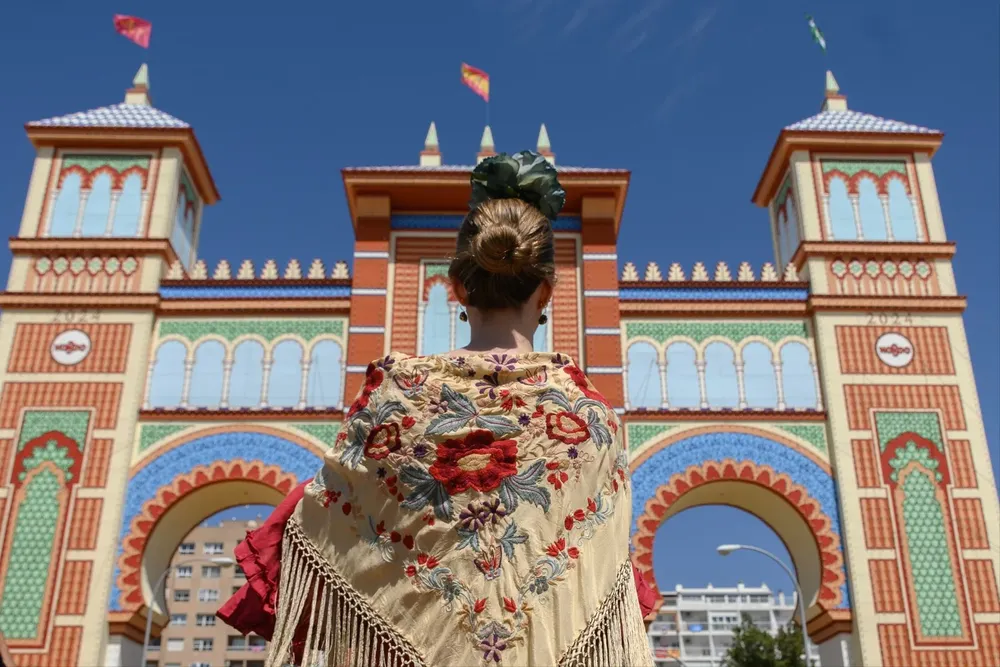 Una mujer vestida de flamenca este domingo en el Real de la Feria de Abril de Sevilla