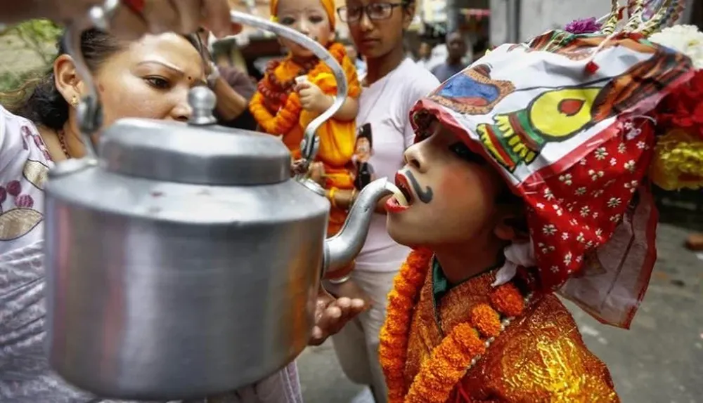 Nepal. Un niño nepalí bebe leche de vaca antes de participar en la procesión del Gai Jatra