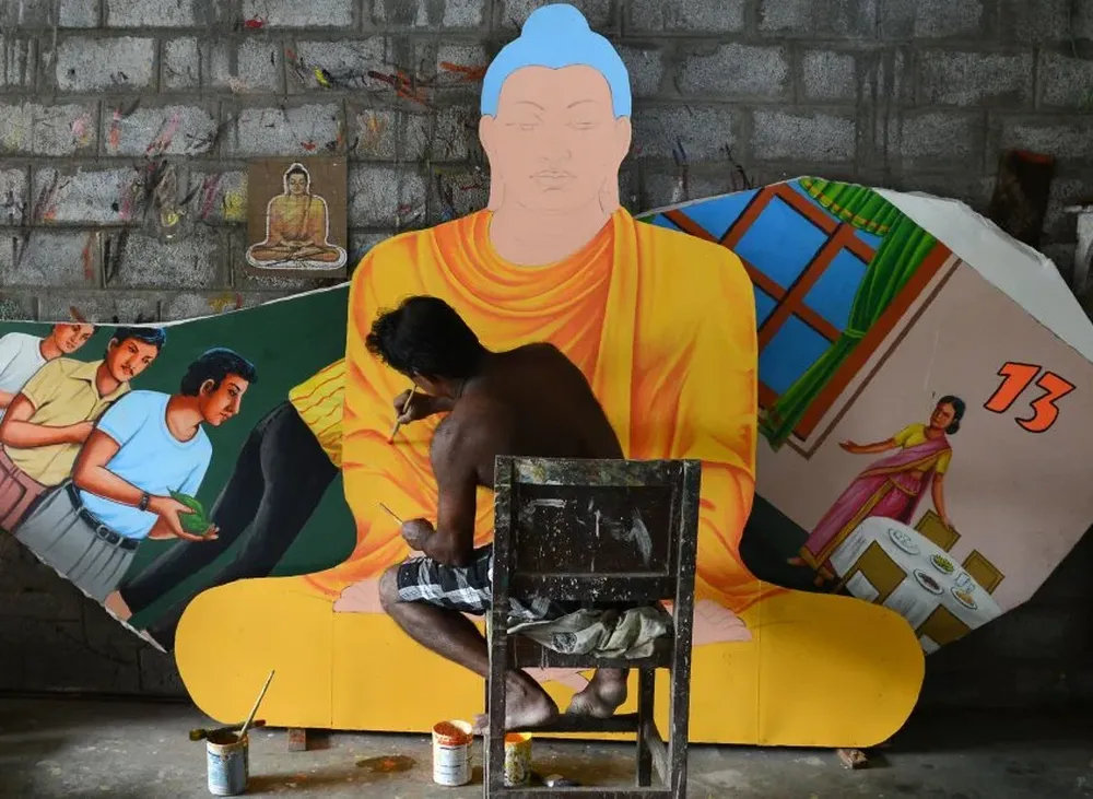 Un artista de Sri Lanka pinta un mural de Buda.