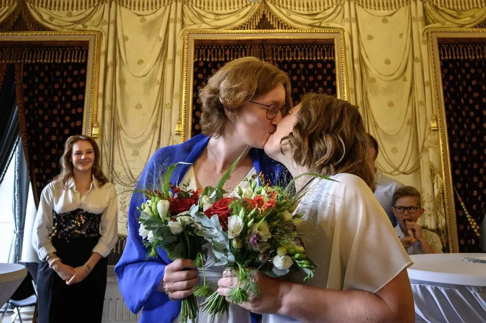 Laure (L) y Aline se besan en su boda en Ginebra después de que la ley suiza de matrimonio para todos entrara en vigor el 1° de julio de 2022.