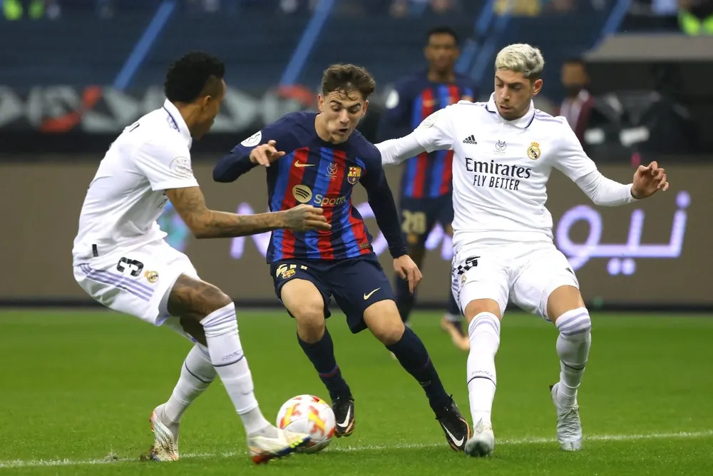 Federico Valverde y Militao marcando en un partido a Gavi de Barcelona en un cl&aacute;sico