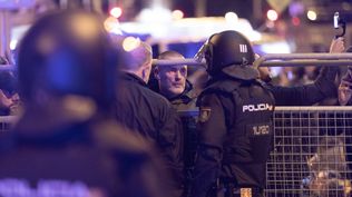 Un policía nacional habla con el líder de Desokupa, Daniel Esteve, frente al Congreso de los Diputados. EUROPA PRESS