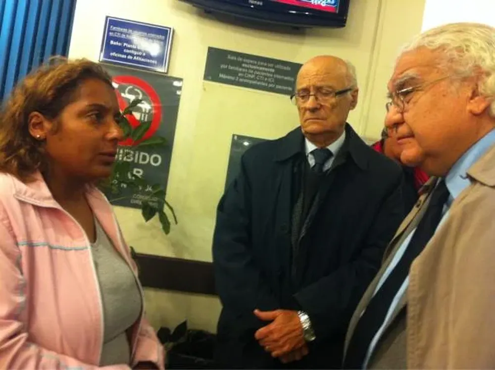 Ricardo Alarcón y Hernán Navascués hablan con la esposa de Alcides, Beatriz Masuí