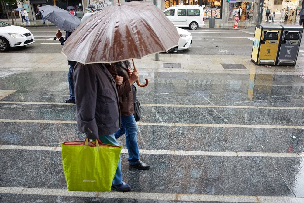 Dos personas se protegen de la lluvia en Madrid. EUROPA PRESS