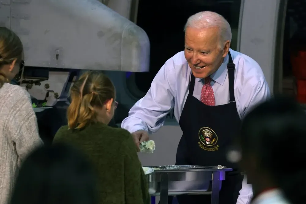 : Joe Biden sirviendo la comida en una base naval en Virginia este domingo, luego de publicar una nota en The Washigton Post .