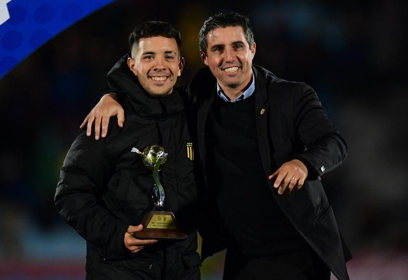 Leo Fernández recibe el premio como MVP de la Copa AUF Uruguay 2025 de manos de Matías Pérez, representante de los grupos de interés, que incluye a los futbolistas, en el Comité Ejecutivo de la AUF